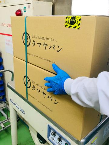 梱包された段ボールにバンドを掛けます