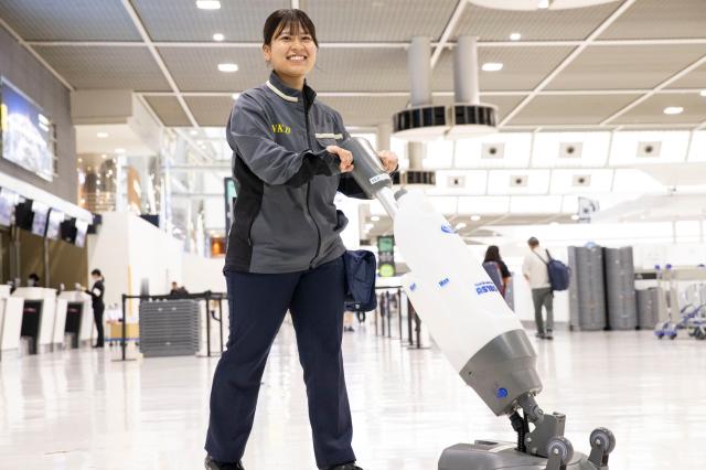 業務用の清掃機で広いロビーをキレイに。歩き回る仕事なので「気づいたら痩せていました！」と笑う先輩も。